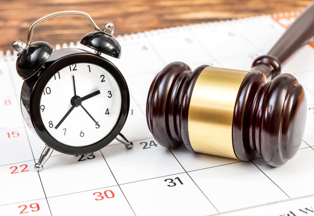 Judge's gavel with clock and calendar on the table.