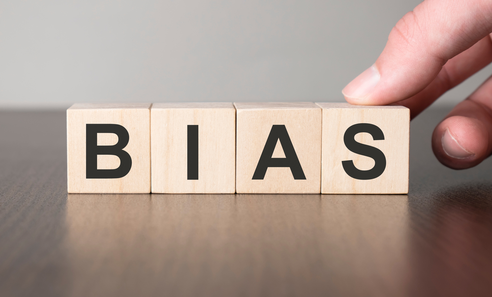 Business bias concept. Hand and fake on wood cube block.