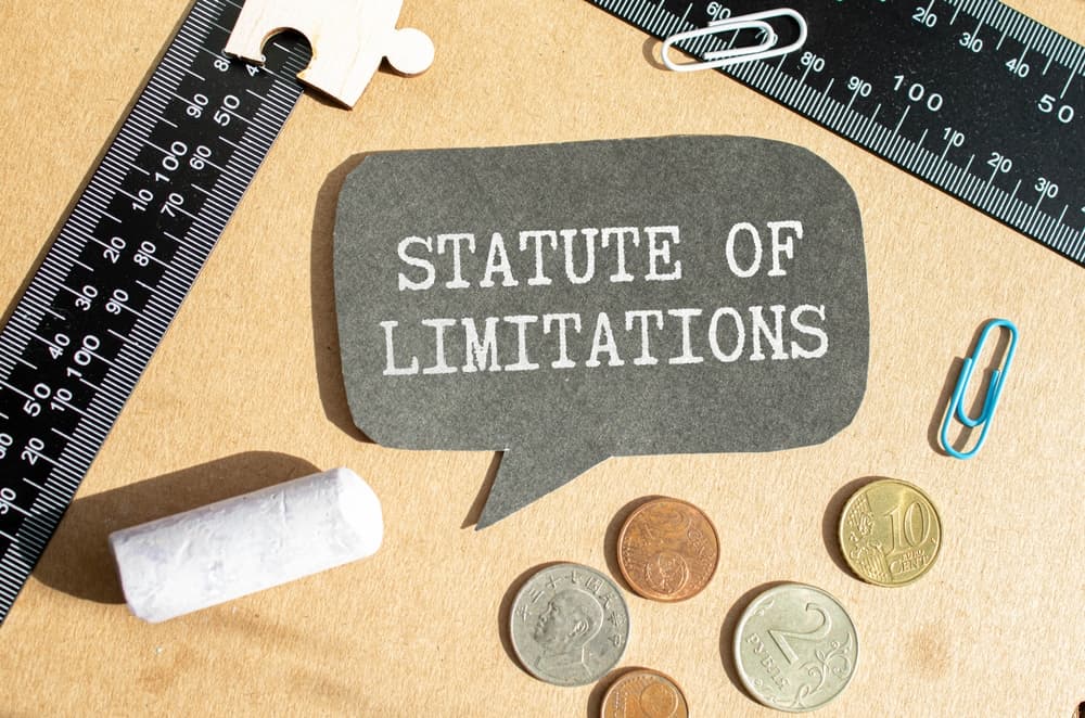 "Statute of Limitations" written on a speech bubble with rulers, coins, paper clips, and chalk around it.