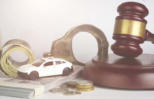 A toy car, handcuffs, and a gavel on top of money, symbolizing legal costs and consequences of car accidents.