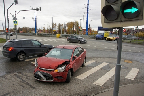 Two cars involved in an intersection collision, one car showing severe front-end damage