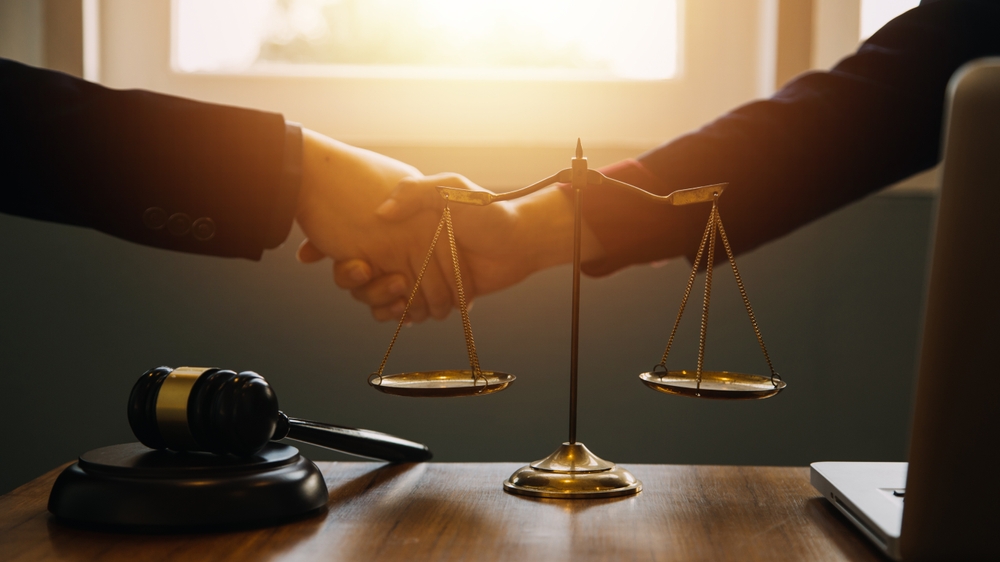 Businessman shaking hands with lawyer to finalize contract agreement, symbolizing legal partnership and successful business deal.