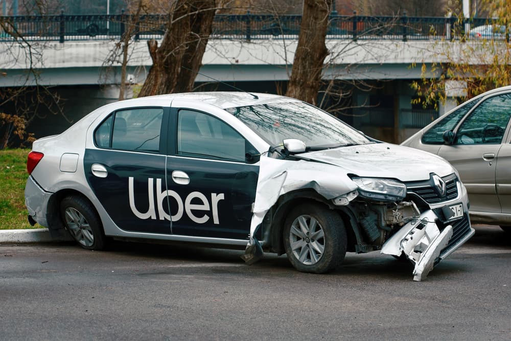 A damaged uber car on the road side