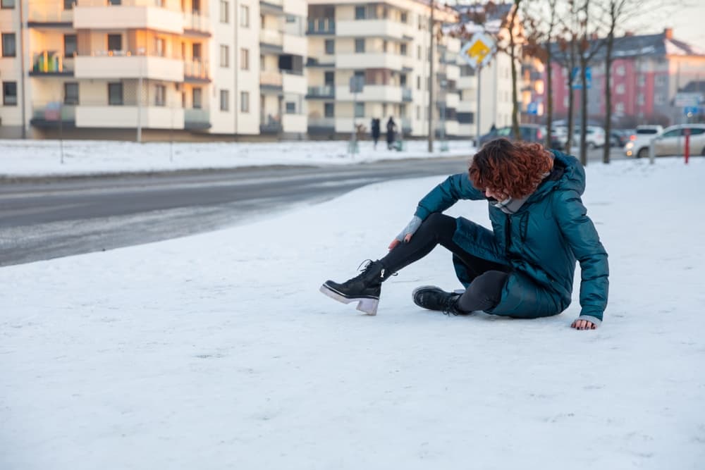 The girl slipped on the icy sidewalk while walking.