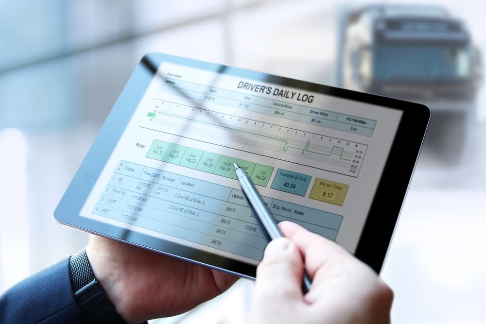 Safety manager is showing to Truck driver electronic logbooks on a tablet