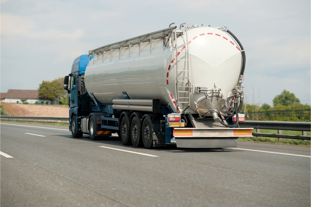 Petrol truck on highway hauling fossil oil refinery products.